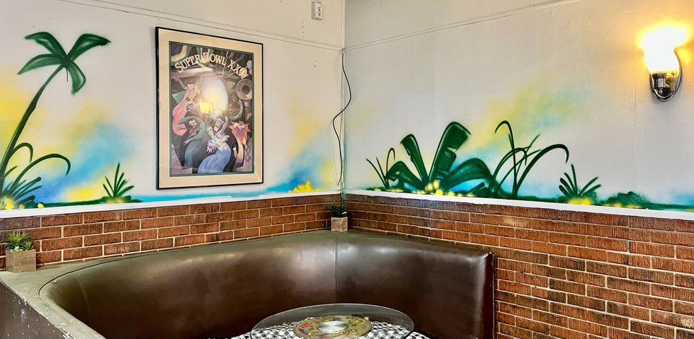 int%20a%20corner%20booth%20with%20palms%20and%20flowers.jpg